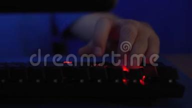 手游戏玩家在电脑键盘上打字。 游戏玩家的游戏键盘。 游戏概念。 背光游戏键盘。